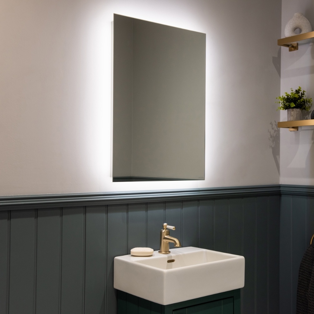 Lifestyle image of the Sensio Lustro Rectangle 700mm x 500mm Rechargeable Backlit LED Mirror mounted on bathroom wall, above a vanity unit & basin